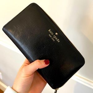 Black Kate spade wallet. Can fit in a purse or used as a hand held wallet.